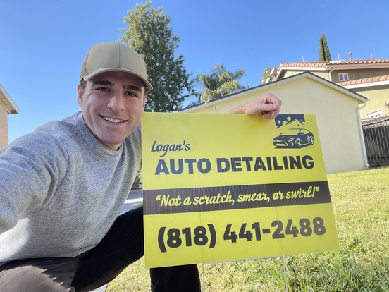 Logan in front of the sign of Logan's Auto Detailing & Ceramic Coating